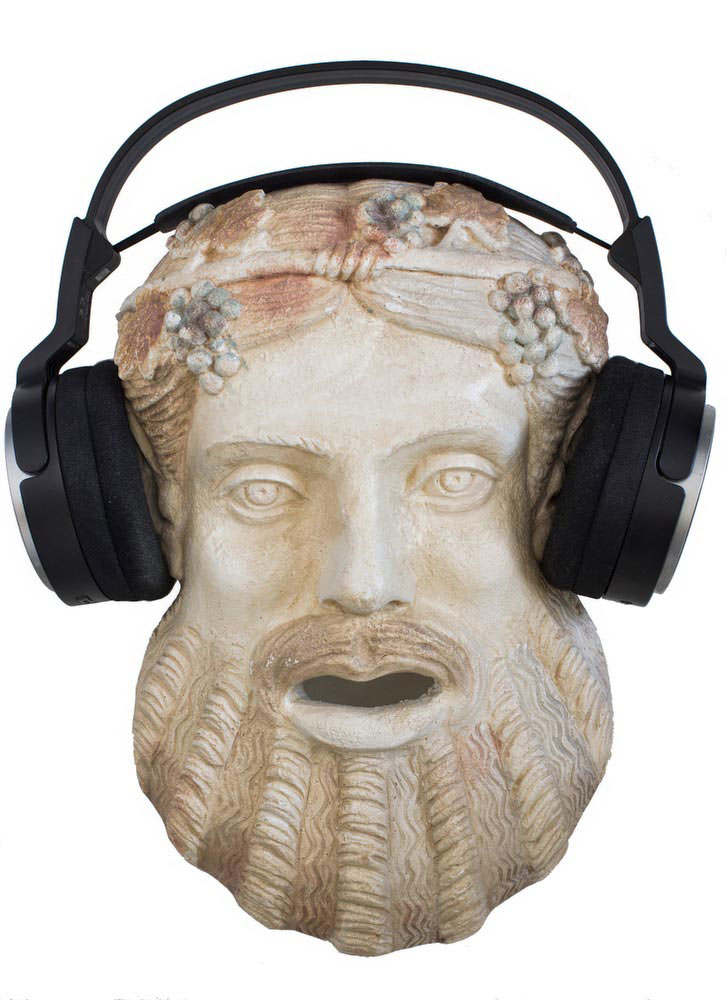 Terracotta mask of ancient Greek god of theatre Dionysus on white, with a modern set of headphones on